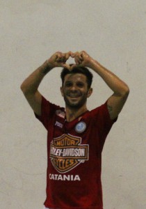 un calciatore forma un cuore con le dita delle mani sopra la testa