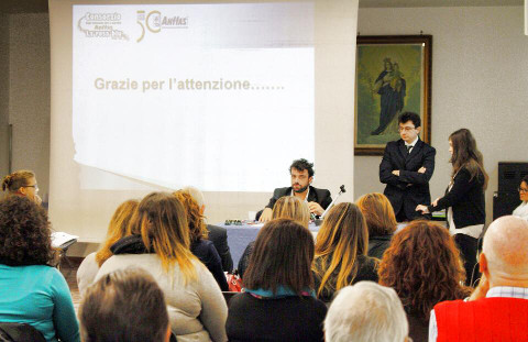 una persona parla seduta davanti al pubblico