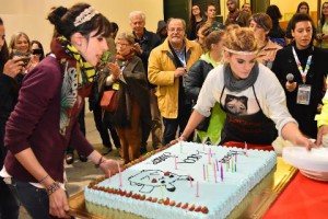 due ragazze sistemano su un tavolo una grande torta
