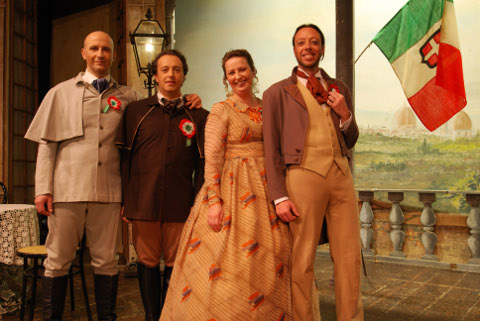 attori con costumi di scena e una bandiera italiana in mano