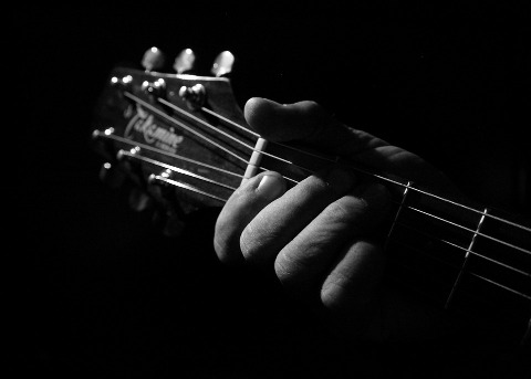 una mano impugna una chitarra